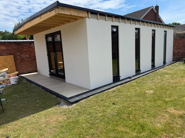 Completed detached garden room with a new paved threshold along the front